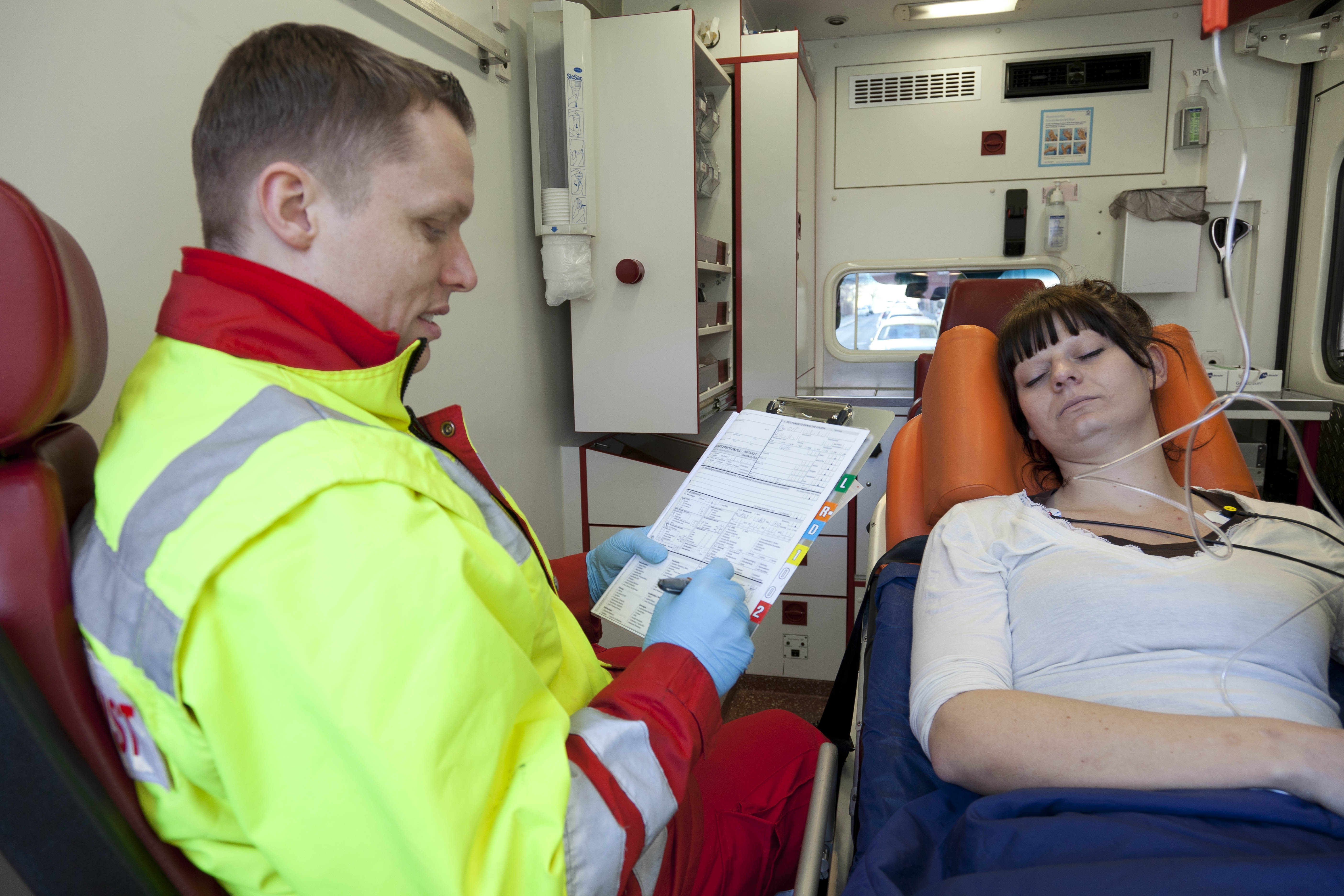 ASB-Rettungsassistent betreut im Rettungswagen eine Patientin.