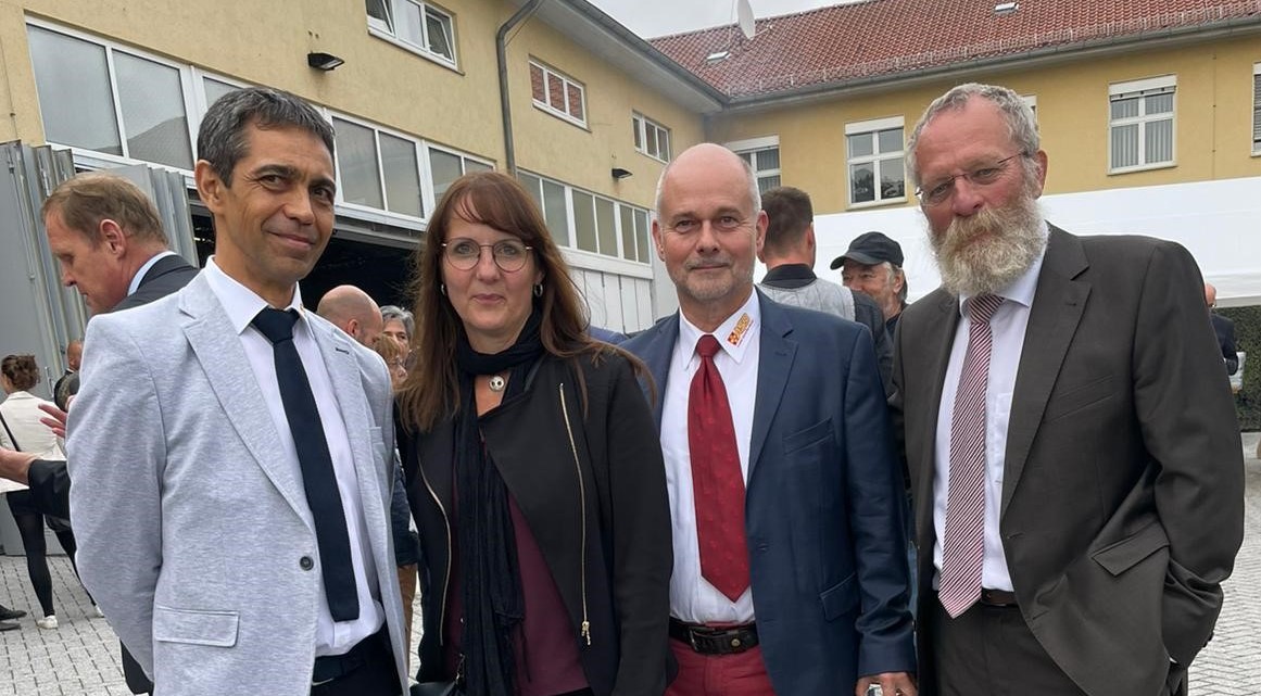 Foto.jpg Fünf Personen stehen in einer Reihe und gucken in die Kamera.