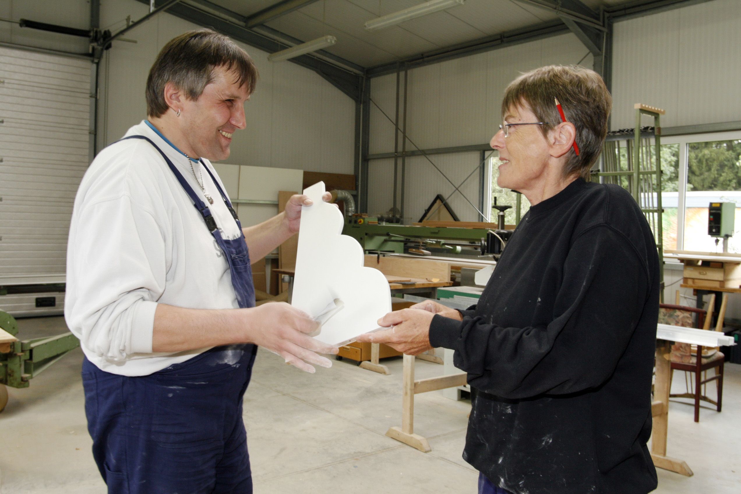 Zwei Männer unterhalten sich in einer Schreinerwerkstatt